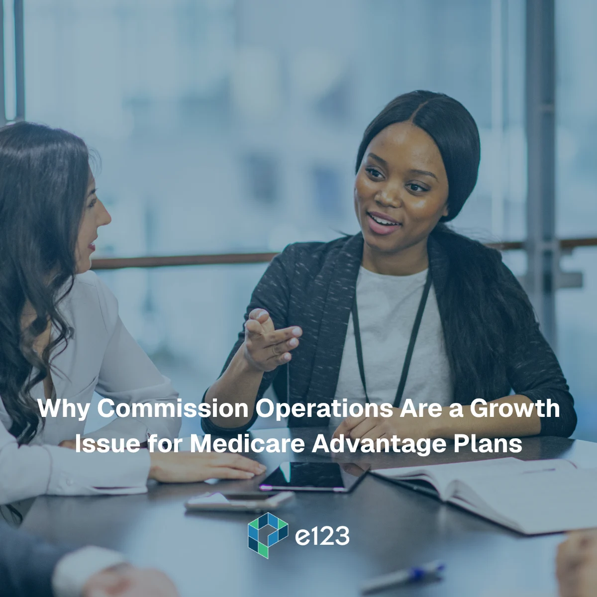 Three women sit at a table having a discussion with papers and a tablet, text overlay reads: Why Commission Operations Are a Growth Issue for Medicare Advantage Plans. Their focused conversation highlights how optimizing commission operations is crucial to driving growth for Medicare Advantage Plans.